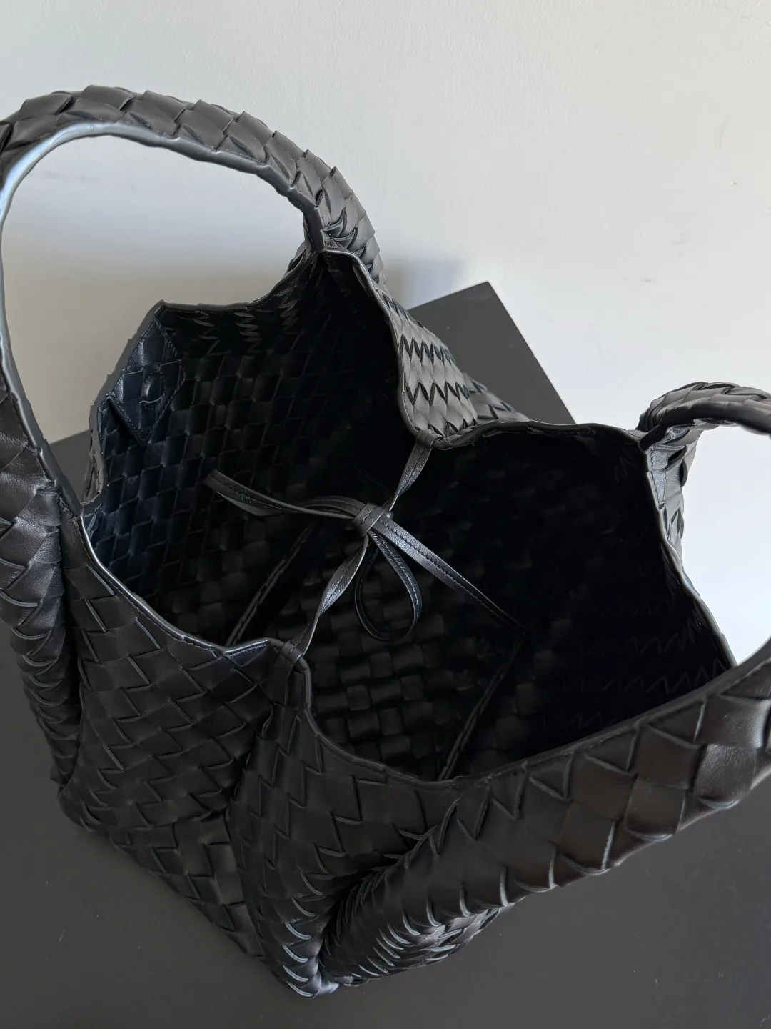 Batch 2160 new products are coming! BOTTEGA VENETA Bottega Veneta's 2025 new Campana shoulder bag is on the market~ First of all, I would like to praise the weight of this bag. As a not too small bag, it is very light for daily use. For people like me who need to carry a lot of belongings when going out, this advantage is great, and it greatly reduces the burden of traveling. 🛍️The shape is a bit like a combination of parachute and jodie. The blunt triangle shape is cute and honest. Carrying it on your back when going shopping is a good mood accelerator. The handles and body of the bag are both classic weaves. A tie is added to the original open design. If it is not tied up, the bag will look like a small vegetable basket when carried. Style number: 844249 Size: 33*20*16.5cm